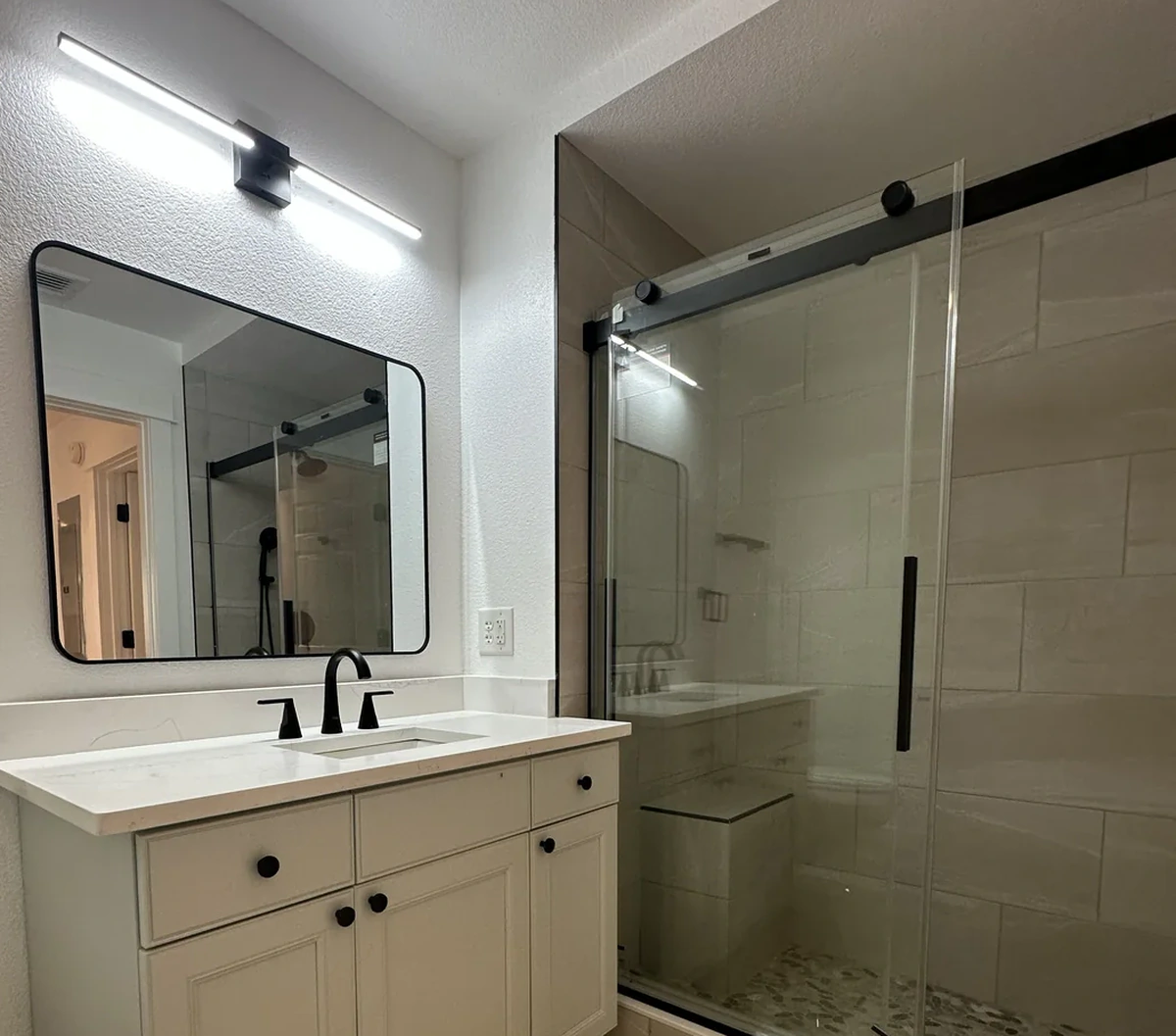 Finished remodeled bathroom with a vanity and mirror by Guy A Remodeling