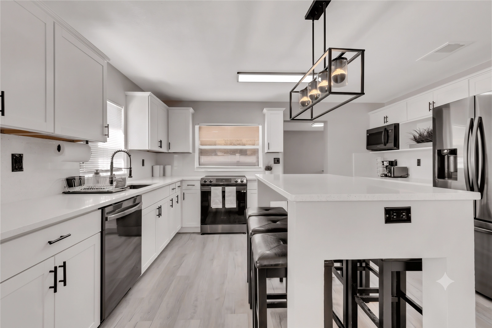 Remodeled St. Cloud kitchen with white cabinets, an island, and pendant lighting by Guy A Remodeling