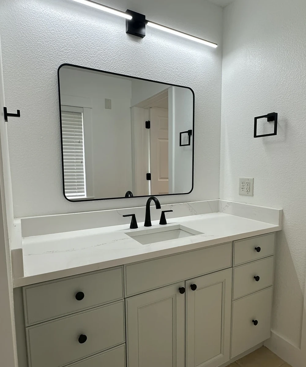 Finished remodeled bathroom with a vanity and mirror by Guy A Remodeling