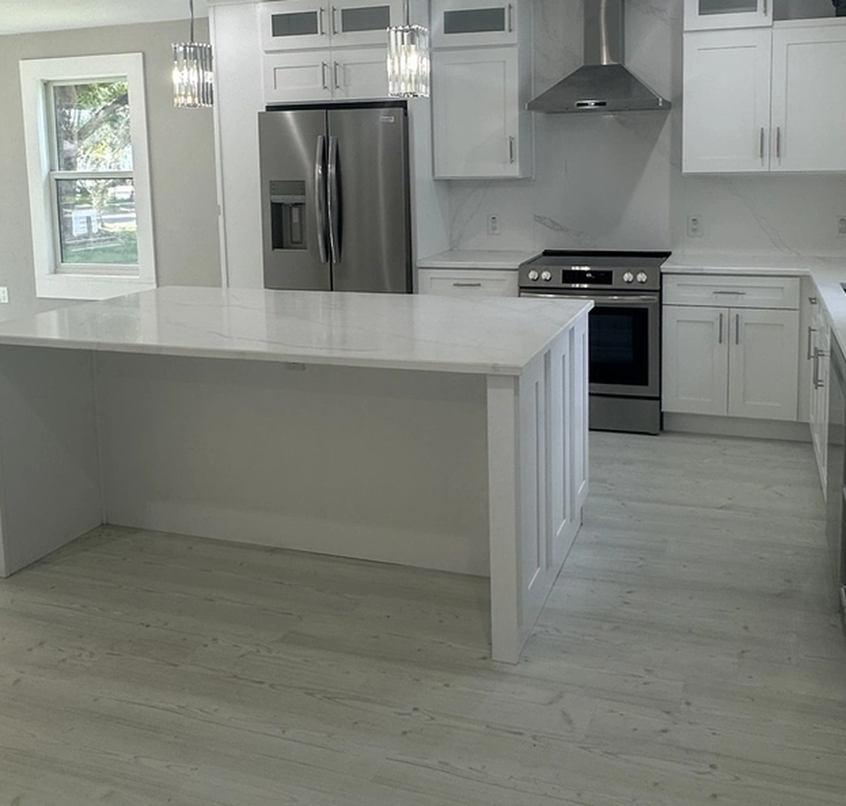Flooring installation in progress with tile being set over a leveled slab by Guy A Remodeling