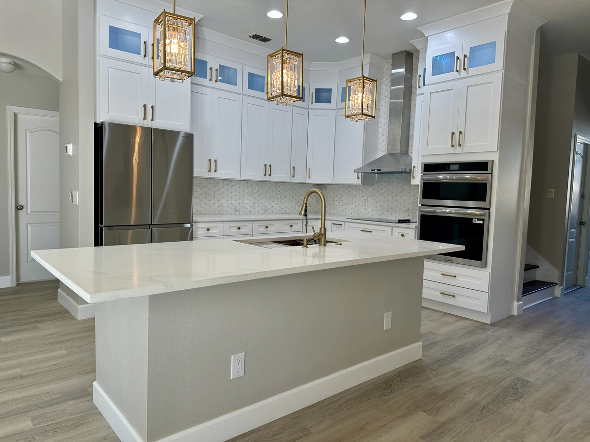Remodeled St. Cloud kitchen with hanging pendant lights over a large island by Guy A Remodeling