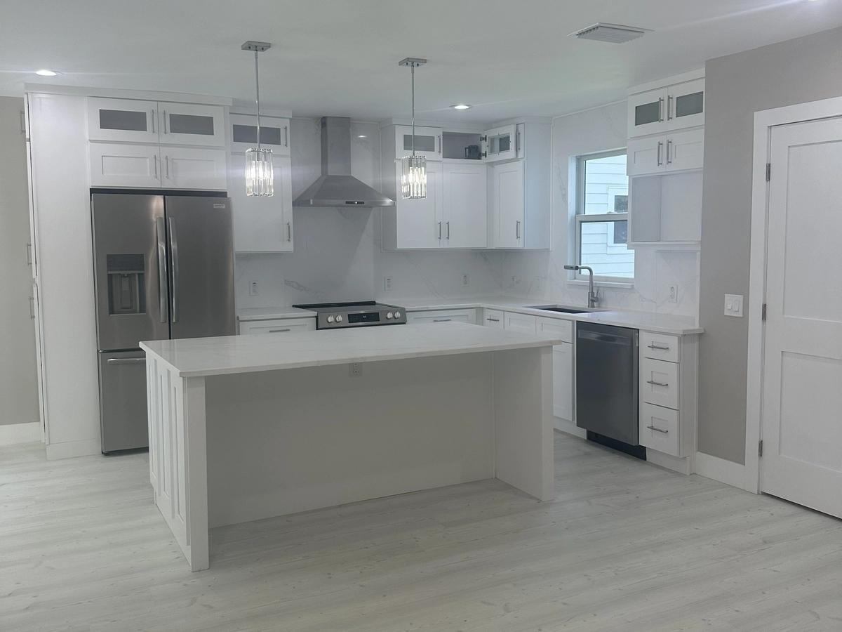 Open concept remodeled kitchen with a large island by Guy A Remodeling