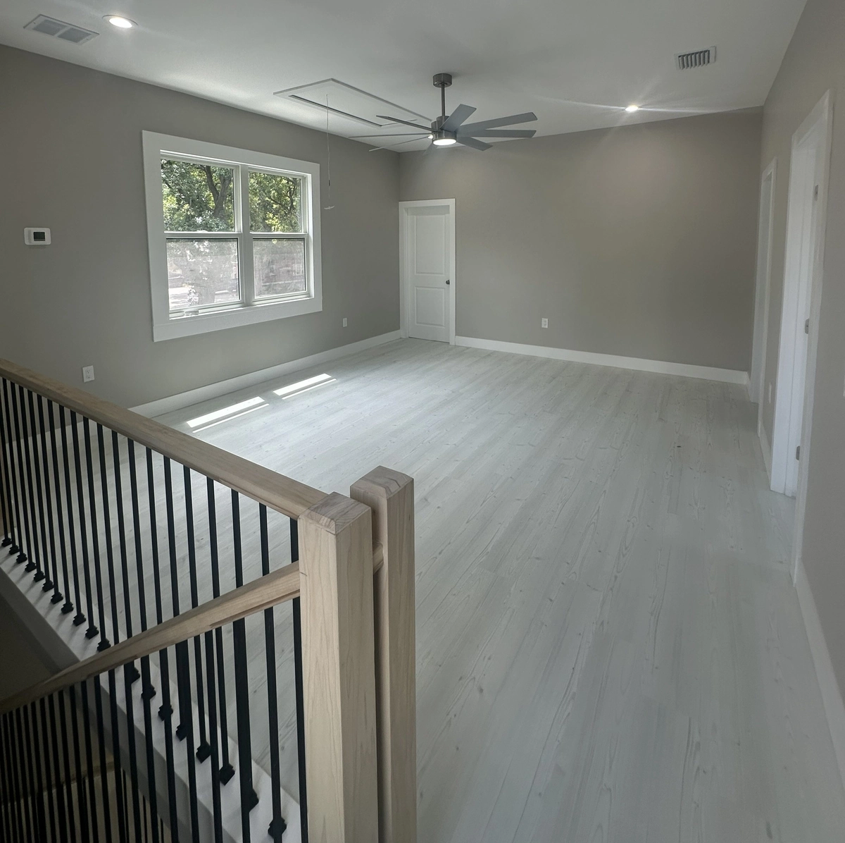 Tile and wood look plank flooring meeting cleanly at a doorway transition by Guy A Remodeling