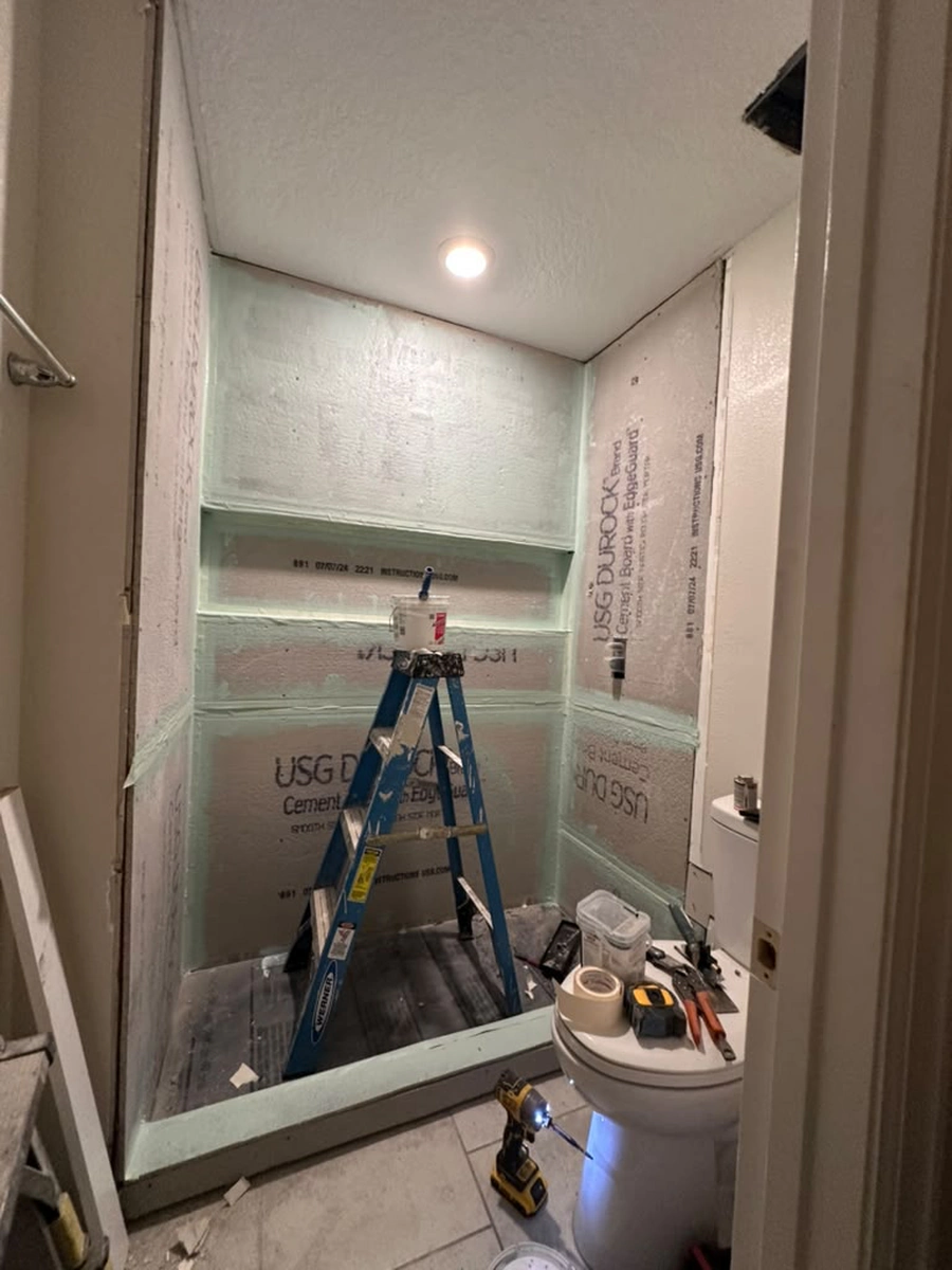 USG Durock cement board installed in the Kissimmee shower with every seam and the full width niche coated in green waterproofing membrane