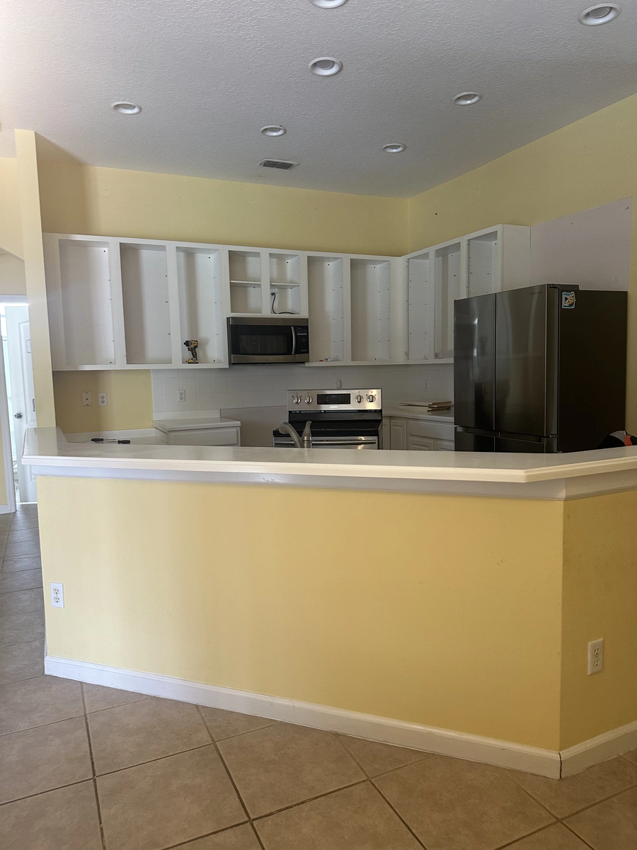 Davenport kitchen before remodeling with dated yellow walls and cream cabinets