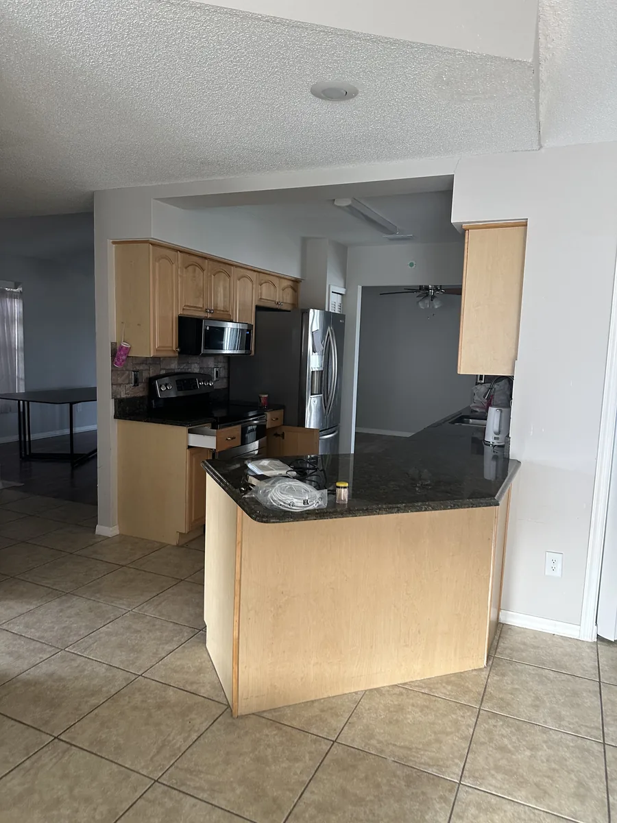 Orlando kitchen before remodeling with dark wood cabinets and black granite