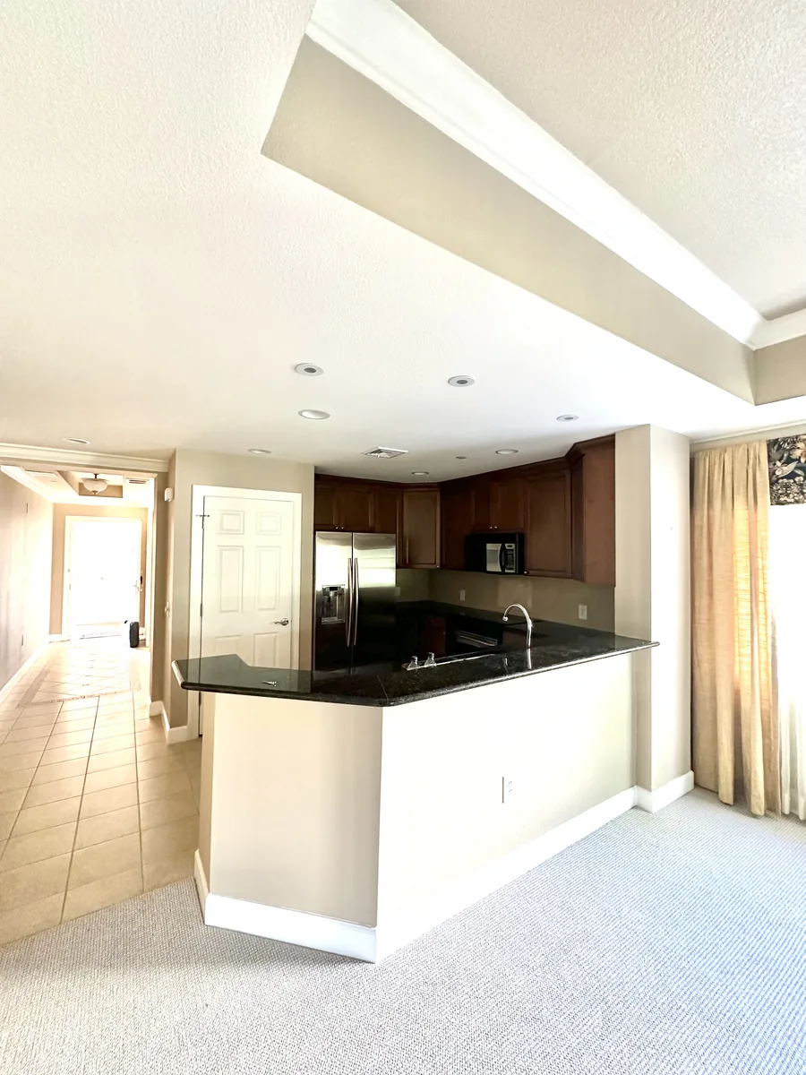 Kissimmee kitchen before remodeling with dated dark oak cabinets and black granite counters